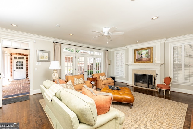 living room featuring crown molding, baseboards, a premium fireplace, french doors, and dark wood-style flooring