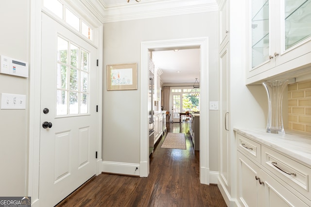 doorway to outside featuring crown molding, baseboards, and dark wood-type flooring