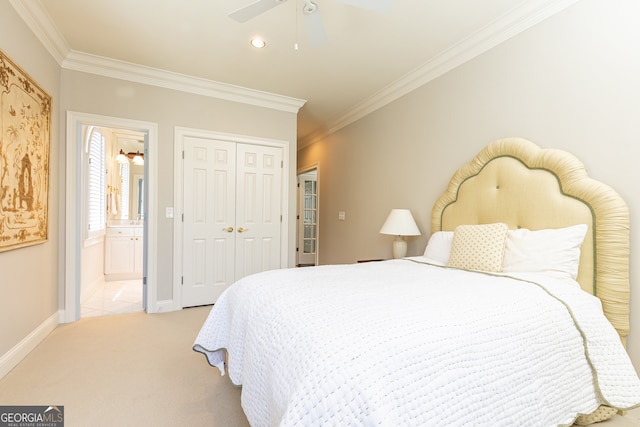 carpeted bedroom featuring baseboards, a closet, ensuite bathroom, and ornamental molding