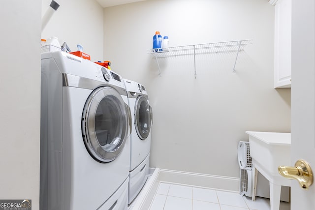 laundry room with light tile patterned floors, cabinet space, independent washer and dryer, and baseboards