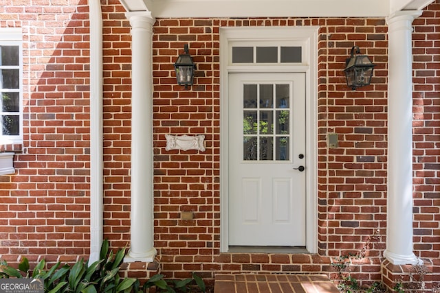 view of exterior entry with brick siding