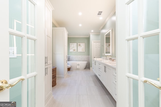 bathroom featuring visible vents, ornamental molding, tile patterned floors, a soaking tub, and vanity