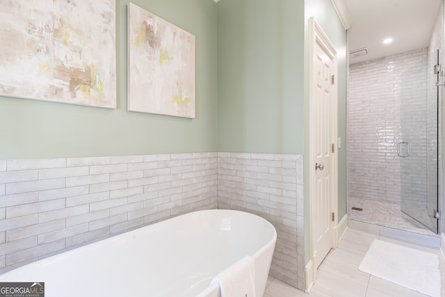 full bathroom with a shower stall, recessed lighting, tile patterned floors, a soaking tub, and tile walls