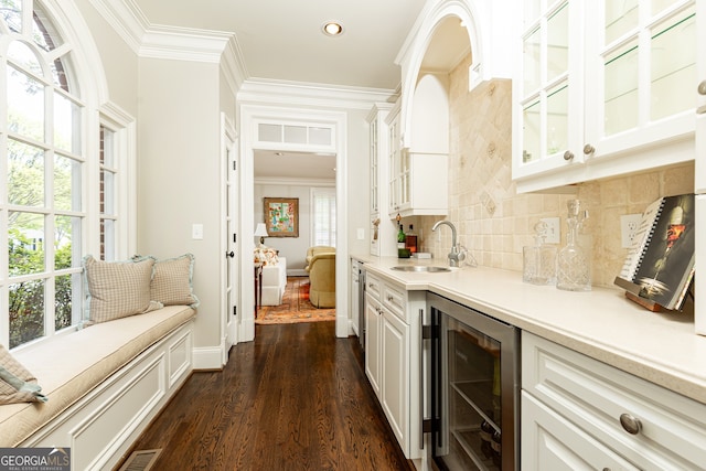 bar featuring crown molding, wine cooler, backsplash, and a sink