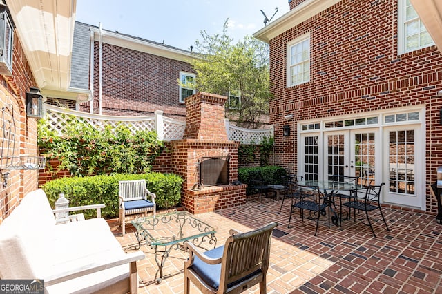 view of patio / terrace featuring an outdoor living space with a fireplace, french doors, and fence