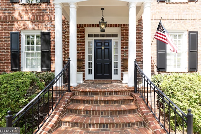 doorway to property featuring brick siding