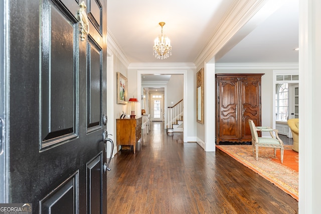 foyer entrance with dark wood-style floors, stairway, crown molding, baseboards, and a chandelier