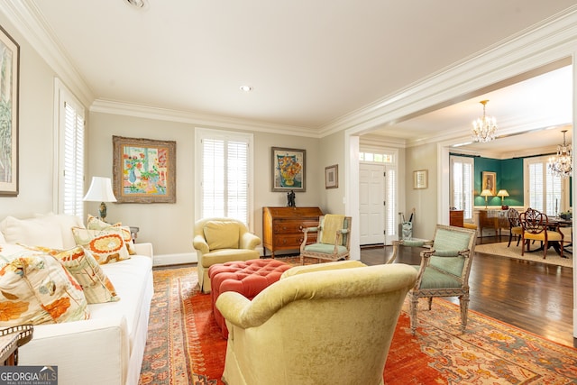 living room featuring a chandelier, dark wood-style floors, baseboards, and ornamental molding