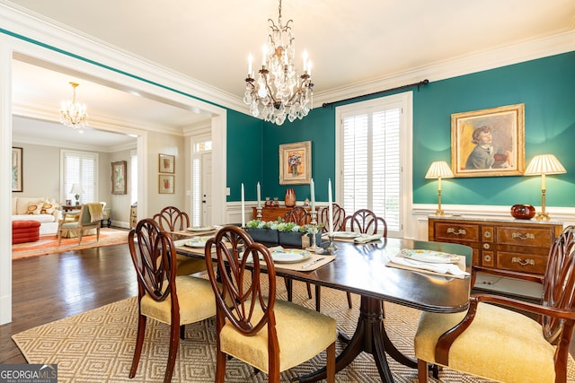 dining room featuring a chandelier, dark wood-style floors, a healthy amount of sunlight, and a wainscoted wall