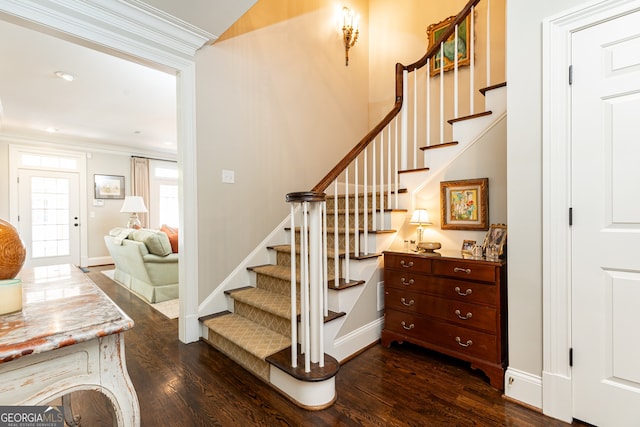 stairway featuring crown molding, wood finished floors, and baseboards