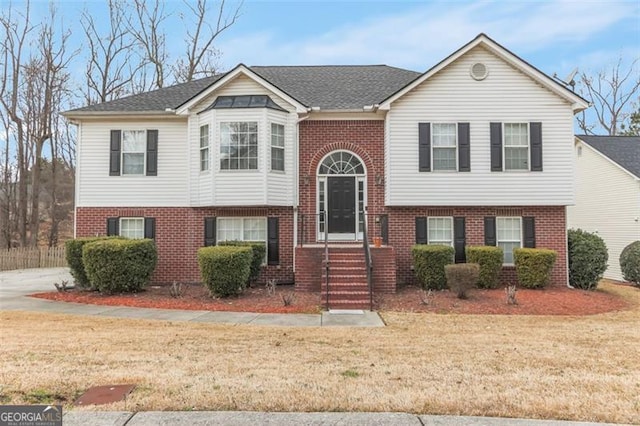 bi-level home with brick siding and a front lawn