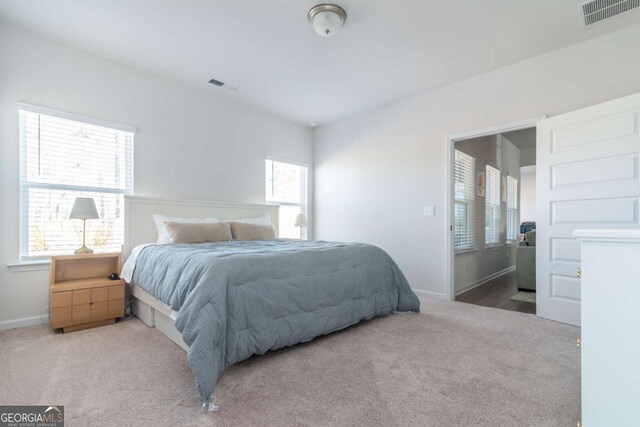 carpeted bedroom with visible vents and baseboards