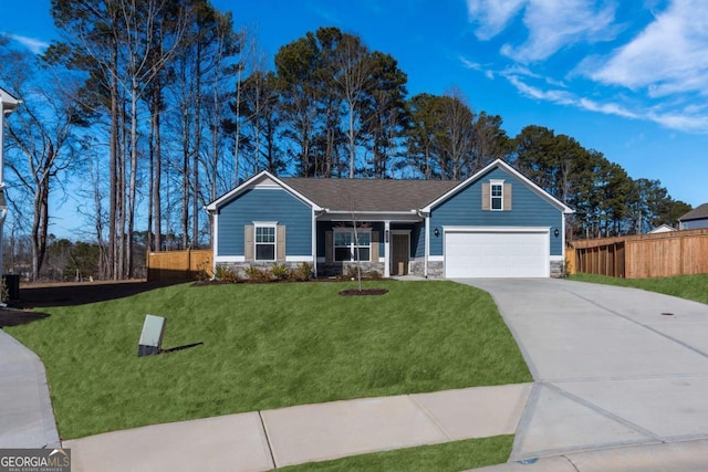 view of front of home with roof with shingles, concrete driveway, fence, stone siding, and a front lawn