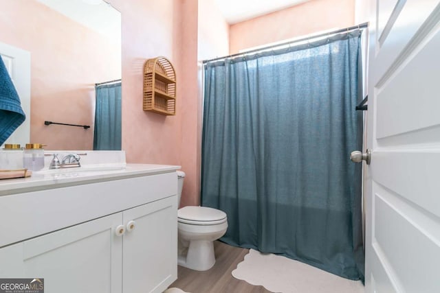 full bathroom featuring toilet, curtained shower, wood finished floors, and vanity