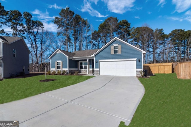 view of front of home with a garage, concrete driveway, stone siding, fence, and a front yard