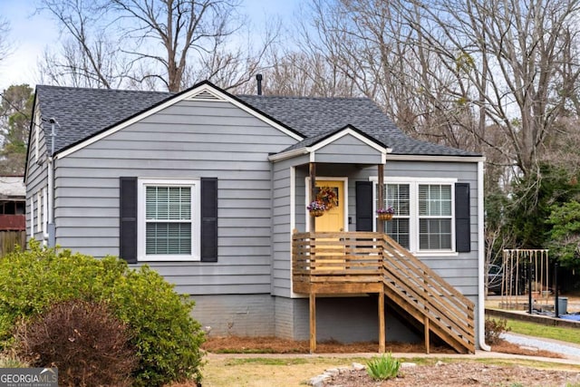 bungalow-style house with a shingled roof and stairway