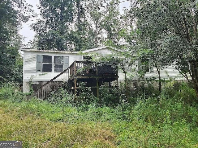 rear view of house with stairway and a wooden deck