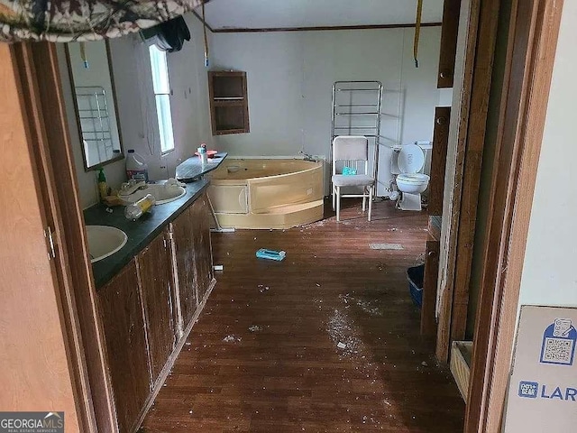 full bathroom featuring a garden tub, toilet, a sink, and hardwood / wood-style flooring