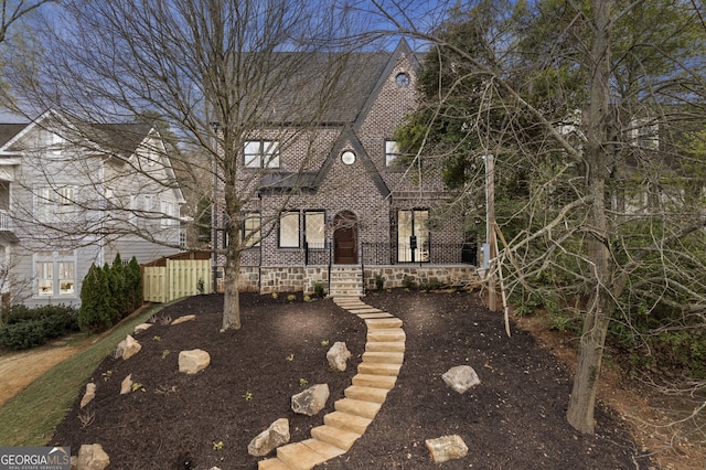 english style home featuring brick siding