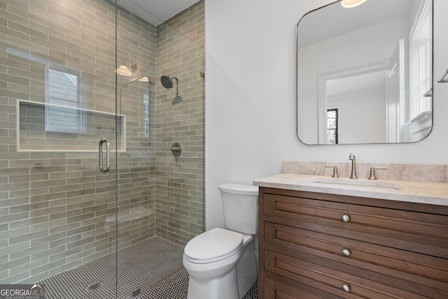 bathroom featuring a stall shower, vanity, and toilet