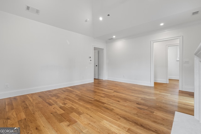 empty room with light wood-style flooring, visible vents, and baseboards