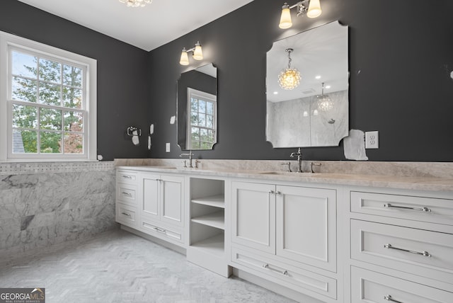 full bathroom featuring double vanity, wainscoting, a sink, and tile walls