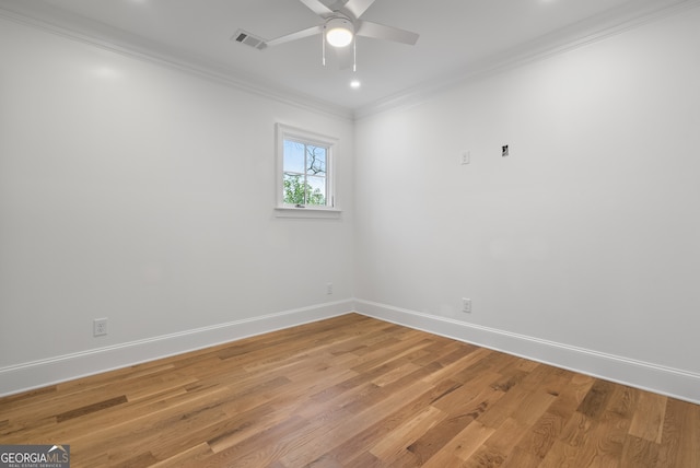 empty room featuring crown molding, visible vents, a ceiling fan, light wood-type flooring, and baseboards