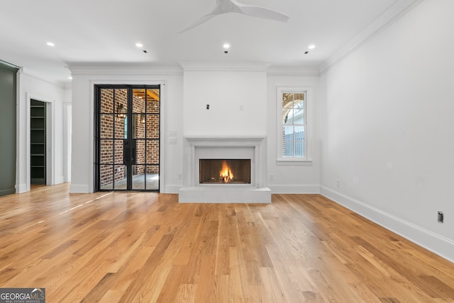 unfurnished living room with baseboards, light wood-style flooring, and crown molding