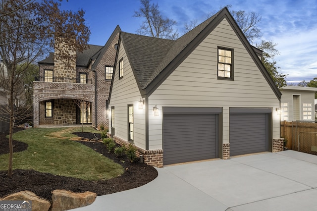 view of front of home with brick siding, a shingled roof, concrete driveway, fence, and a garage