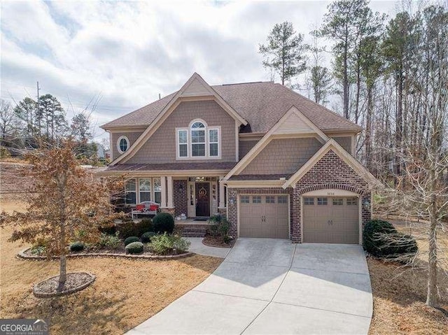 craftsman inspired home featuring a garage, brick siding, driveway, and a porch