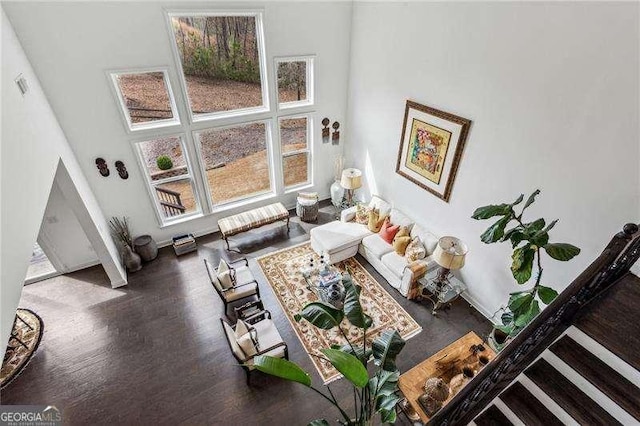 living room with a high ceiling, baseboards, and wood finished floors