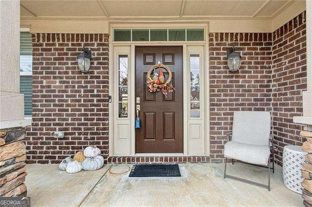 doorway to property with brick siding