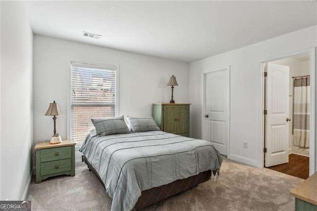 bedroom featuring light colored carpet, visible vents, and baseboards