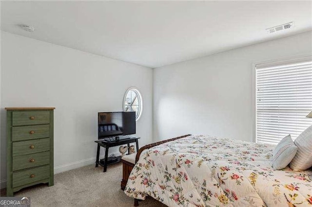 bedroom featuring light carpet, visible vents, and baseboards