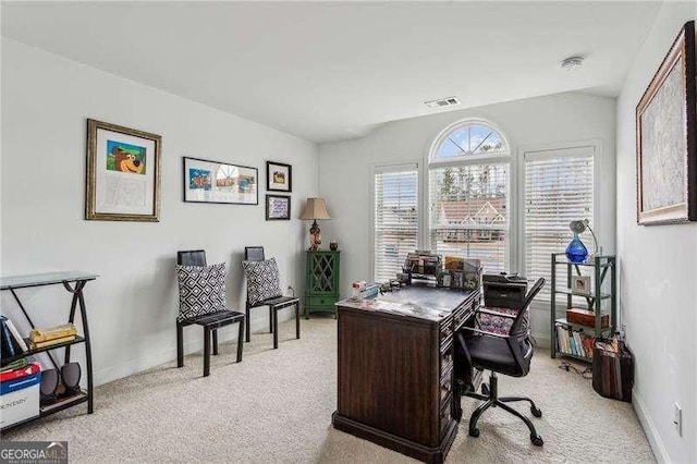 home office with lofted ceiling, light carpet, visible vents, and baseboards