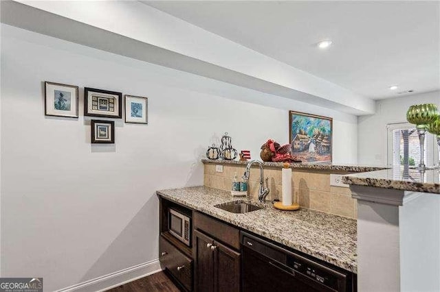 bar with decorative backsplash, dark wood-type flooring, a sink, dishwasher, and baseboards