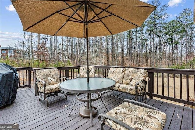 wooden terrace featuring area for grilling and outdoor lounge area