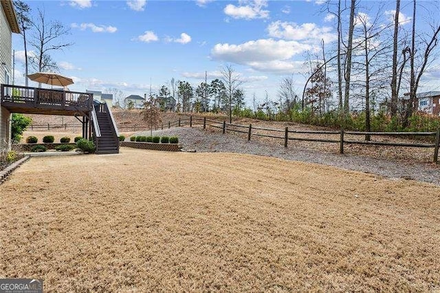 view of yard with fence, stairway, and a deck