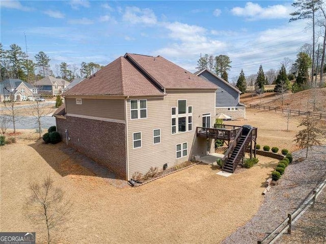 view of side of home featuring stairway and a deck