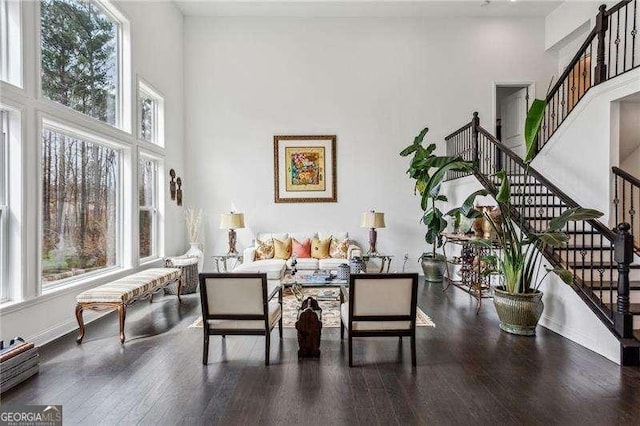 living room with a high ceiling, stairway, wood-type flooring, and baseboards