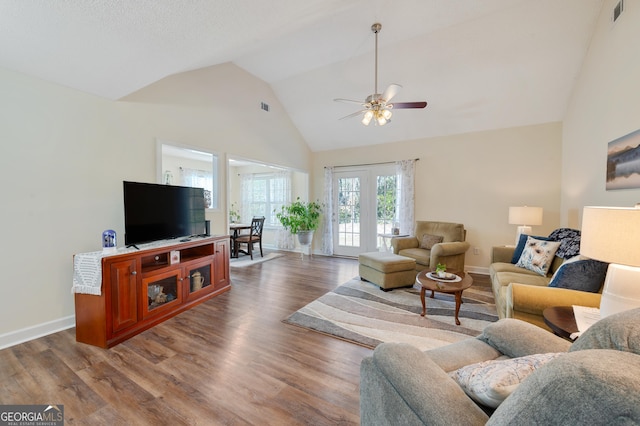 living room featuring high vaulted ceiling, visible vents, and wood finished floors