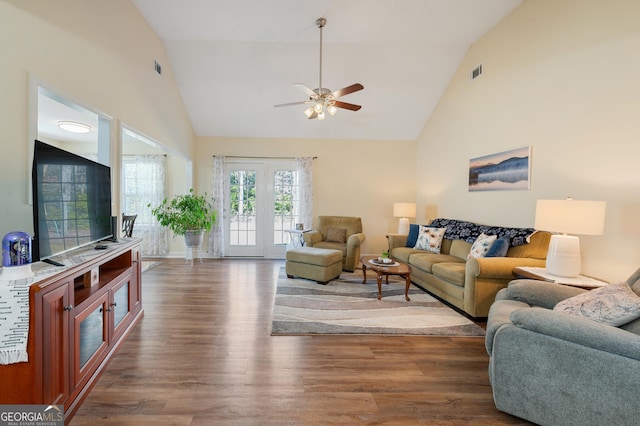 living room with high vaulted ceiling, a ceiling fan, visible vents, and wood finished floors