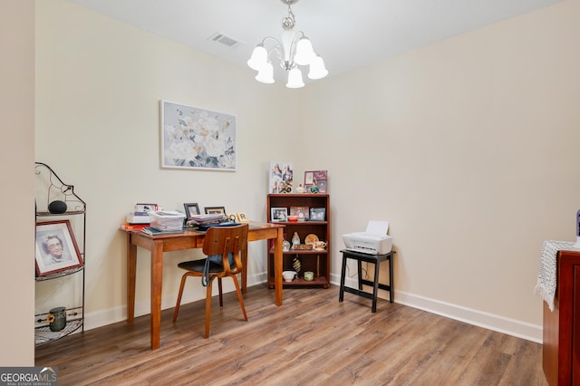 office area with a notable chandelier, visible vents, baseboards, and wood finished floors