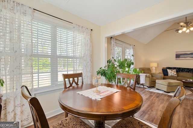 dining area featuring lofted ceiling, baseboards, a ceiling fan, and wood finished floors