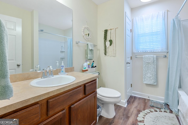 bathroom with toilet, wood finished floors, vanity, baseboards, and a shower with curtain