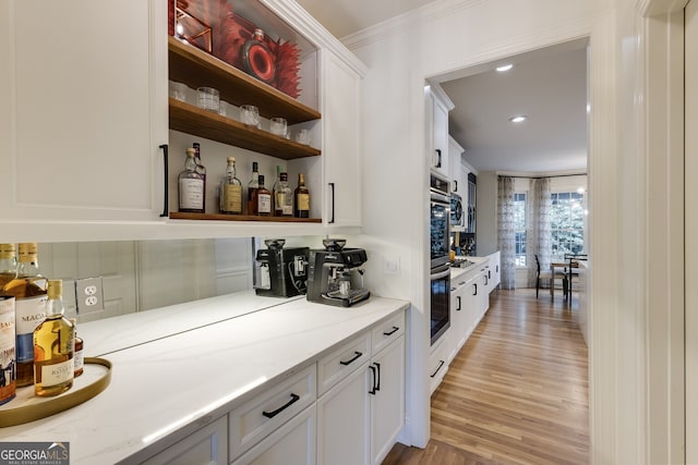 bar with a dry bar, light wood-style flooring, crown molding, and recessed lighting