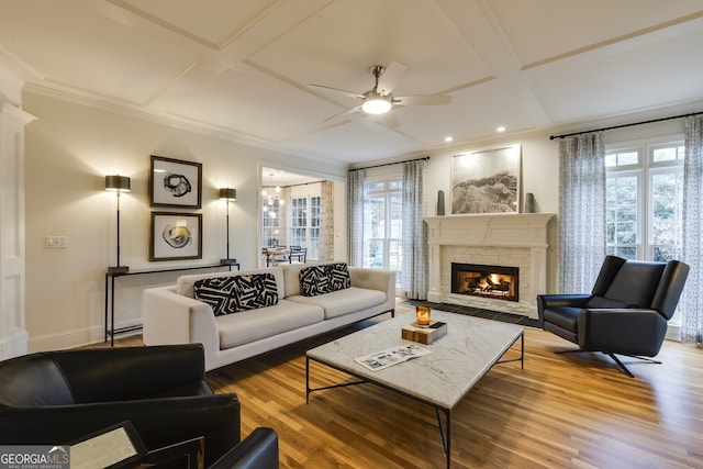 living area with coffered ceiling, plenty of natural light, a fireplace, and wood finished floors