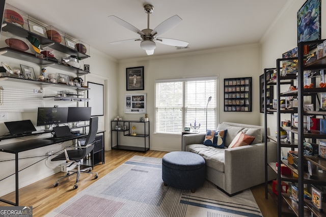 home office featuring wood finished floors, visible vents, a ceiling fan, baseboards, and ornamental molding