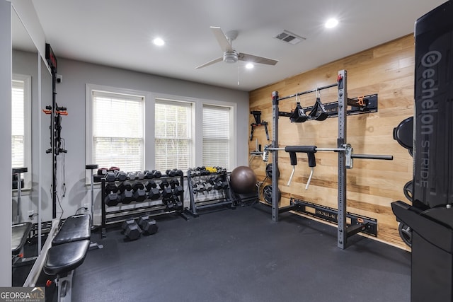 workout room with ceiling fan, recessed lighting, visible vents, and wooden walls