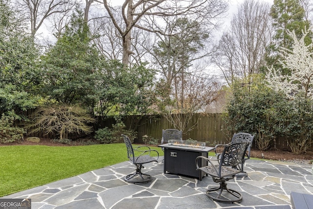 view of patio with fence and a fire pit